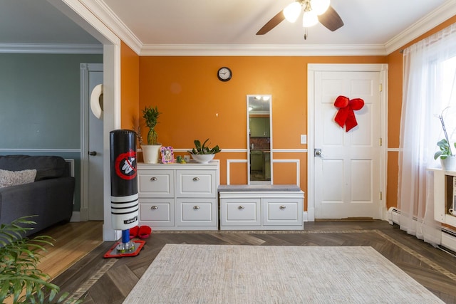 interior space with a baseboard heating unit, a ceiling fan, dark wood-style flooring, and ornamental molding