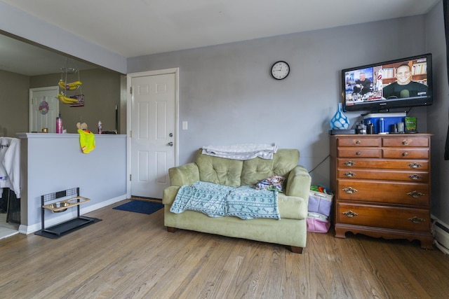 living area with baseboards and wood finished floors