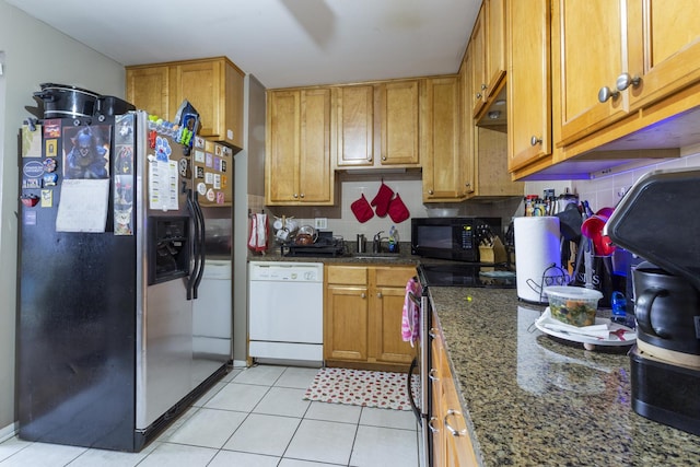 kitchen with brown cabinetry, stainless steel appliances, decorative backsplash, and light tile patterned floors