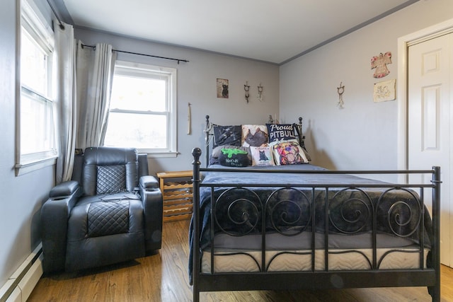 bedroom featuring a baseboard radiator and wood finished floors