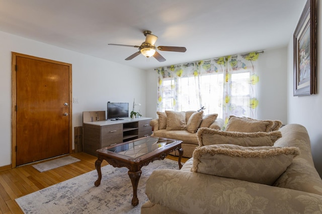 living area featuring light wood-type flooring and ceiling fan