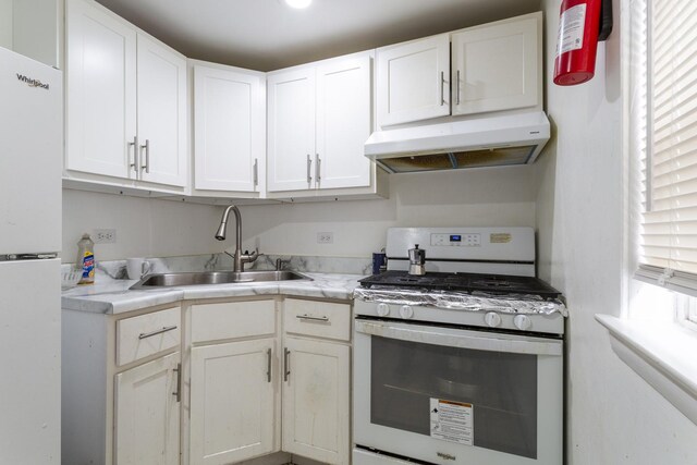 kitchen featuring a sink, light countertops, gas range oven, under cabinet range hood, and white cabinetry