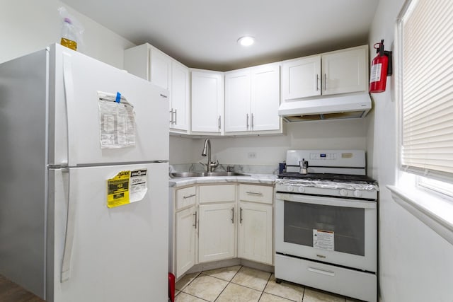 kitchen with under cabinet range hood, light countertops, white appliances, white cabinetry, and a sink