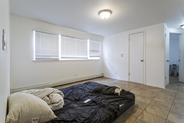 bedroom with a baseboard heating unit and baseboards