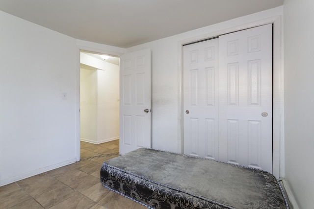 bedroom with baseboards and a closet