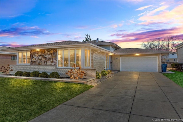 ranch-style home featuring driveway, an attached garage, a yard, stone siding, and brick siding