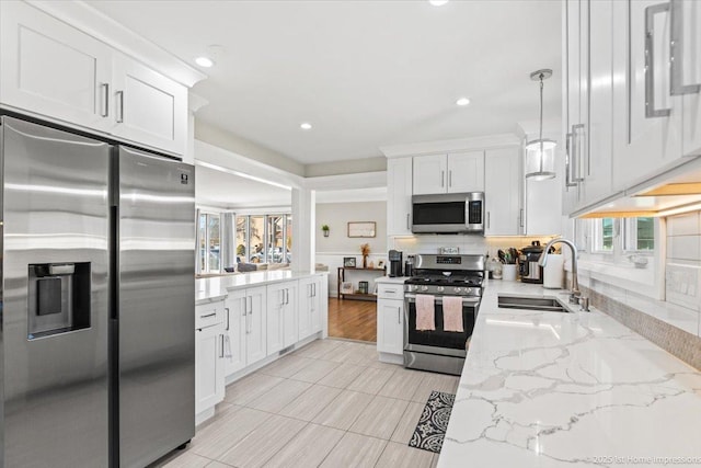 kitchen featuring backsplash, appliances with stainless steel finishes, white cabinetry, and a sink