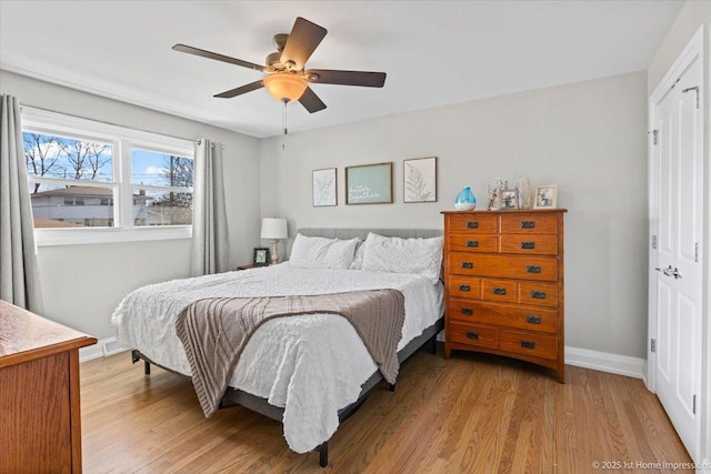 bedroom featuring a closet, ceiling fan, baseboards, and light wood-style floors