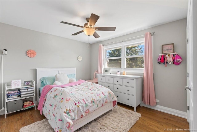 bedroom with baseboards, wood finished floors, and a ceiling fan