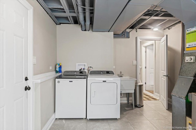 laundry room featuring a sink, light tile patterned flooring, washing machine and dryer, and laundry area