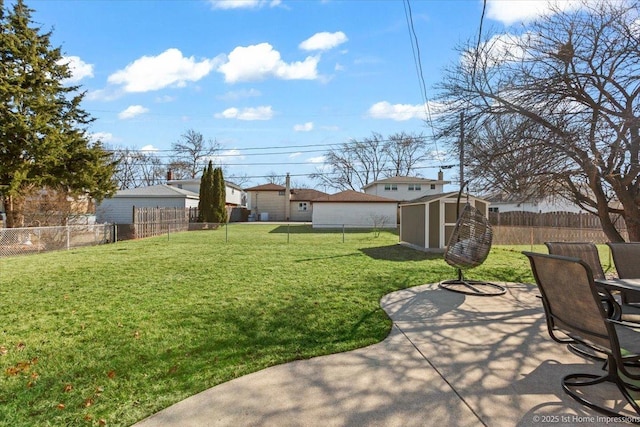 view of yard with a patio area, an outdoor structure, a fenced backyard, and a shed