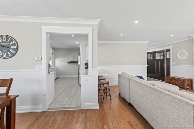 living room featuring recessed lighting, wood finished floors, wainscoting, and ornamental molding