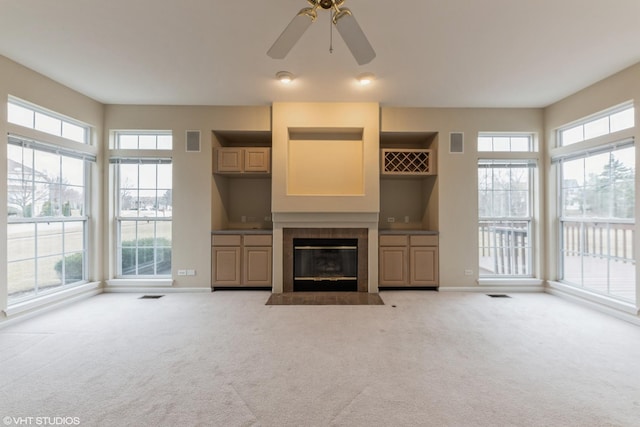 unfurnished living room featuring visible vents, carpet floors, baseboards, and a fireplace