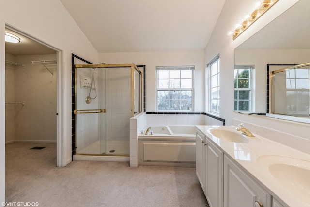 full bathroom with a sink, a garden tub, a shower stall, and vaulted ceiling