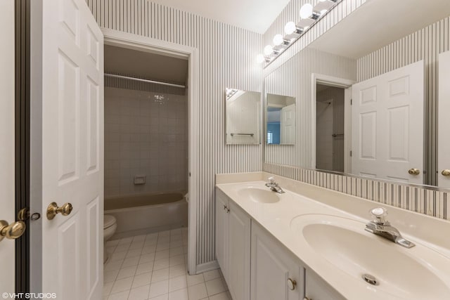 bathroom featuring wallpapered walls, tile patterned floors, toilet, and a sink