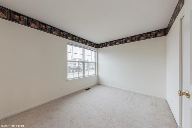 carpeted spare room featuring baseboards and visible vents