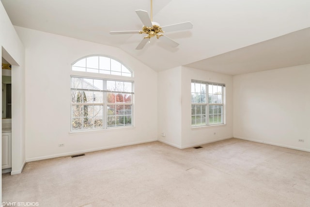 spare room with visible vents, light carpet, lofted ceiling, baseboards, and ceiling fan