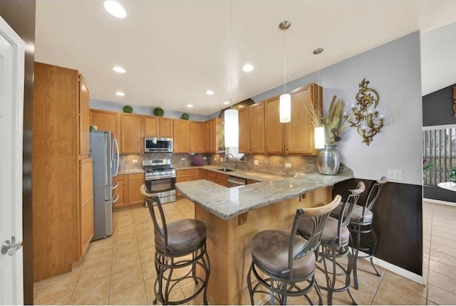 26800 Basswood Cir, Plainfield, IL 60585 - kitchen featuring a breakfast bar, decorative backsplash, a peninsula, and stainless steel appliances