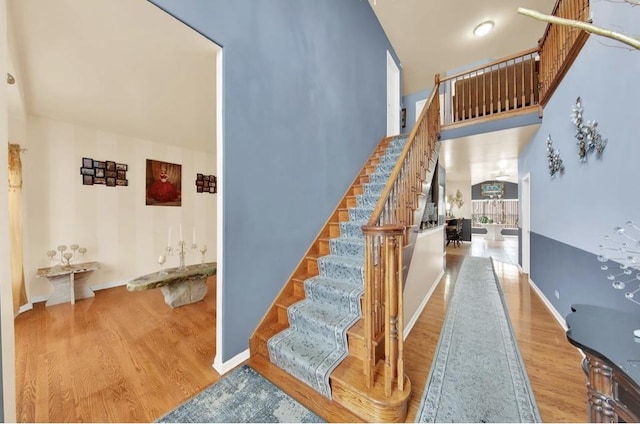 26800 Basswood Cir, Plainfield, IL 60585 - stairway with baseboards, wood finished floors, and a towering ceiling