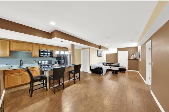 26800 Basswood Cir, Plainfield, IL 60585 - kitchen with a sink, tasteful backsplash, wood finished floors, appliances with stainless steel finishes, and baseboards