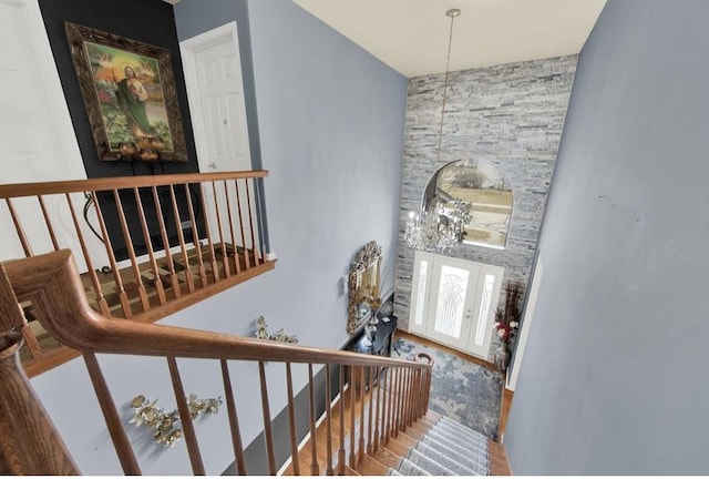 26800 Basswood Cir, Plainfield, IL 60585 - stairway featuring french doors, a notable chandelier, wood finished floors, and a towering ceiling