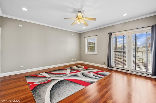 empty room featuring baseboards, wood finished floors, and ornamental molding