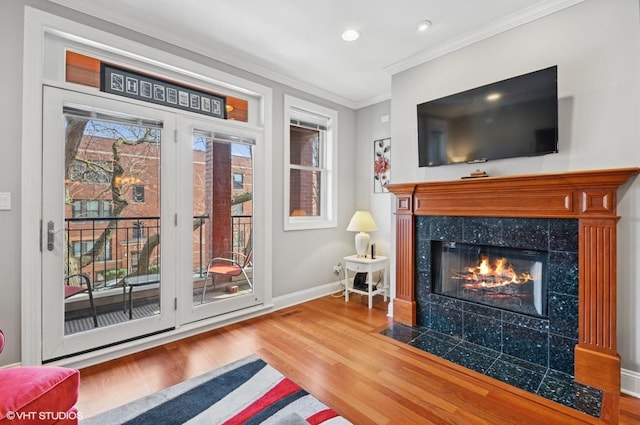 living area featuring ornamental molding, wood finished floors, recessed lighting, a fireplace, and baseboards