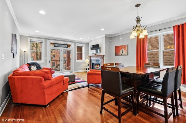 dining room featuring wood finished floors, baseboards, recessed lighting, a high end fireplace, and ornamental molding