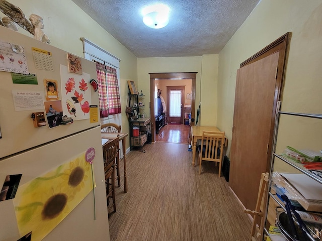 corridor featuring a textured ceiling and wood finished floors