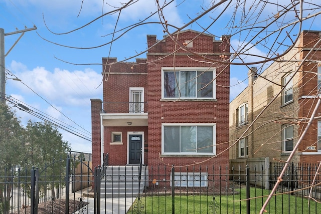 view of front of property featuring a fenced front yard, brick siding, and a gate