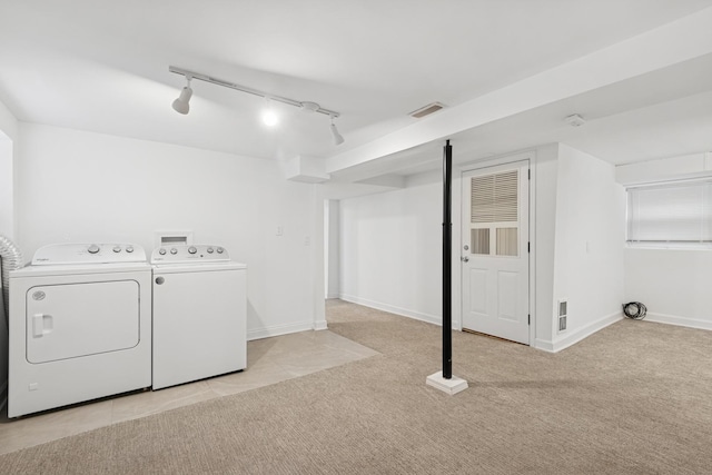 laundry room featuring visible vents, baseboards, washing machine and dryer, light colored carpet, and laundry area