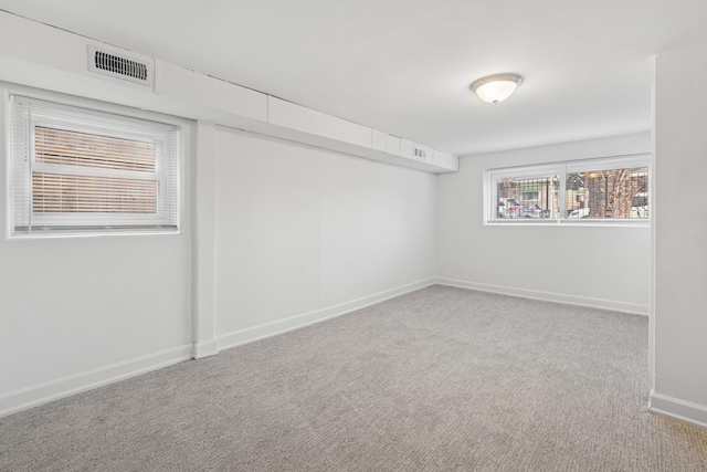 carpeted empty room featuring visible vents and baseboards