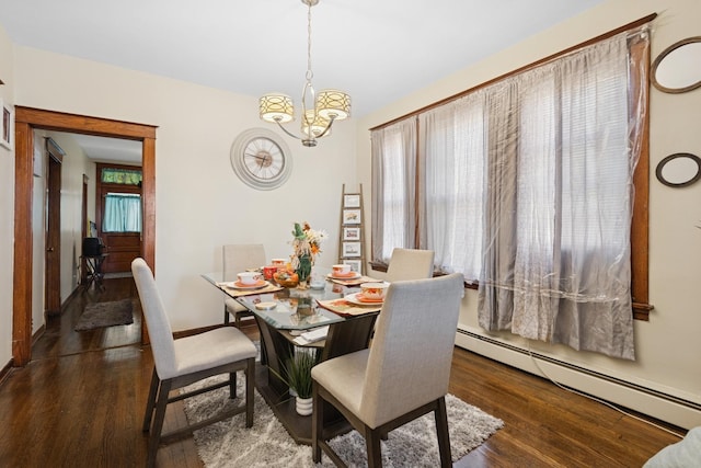 dining room featuring baseboard heating, an inviting chandelier, and wood finished floors