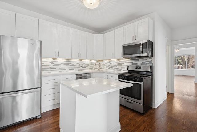 kitchen with light countertops, dark wood-style floors, appliances with stainless steel finishes, and a sink