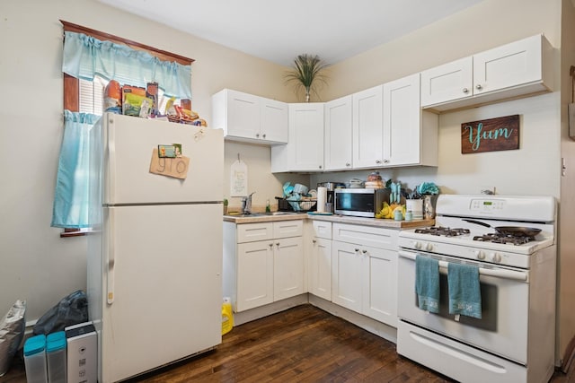 kitchen featuring white appliances, a sink, light countertops, dark wood-type flooring, and white cabinetry