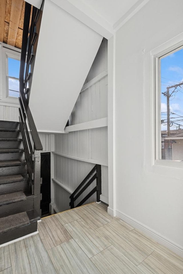 staircase featuring plenty of natural light and baseboards