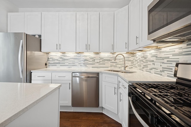 kitchen featuring a sink, light stone countertops, appliances with stainless steel finishes, and white cabinetry