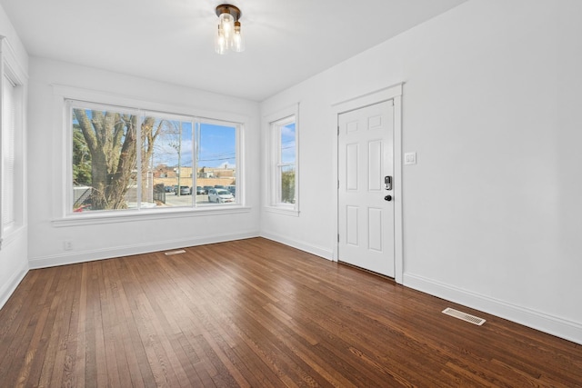 foyer with visible vents, baseboards, and hardwood / wood-style flooring