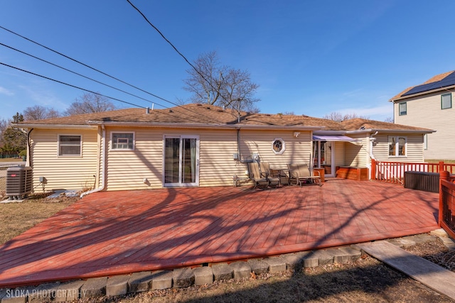 rear view of house featuring cooling unit and a wooden deck