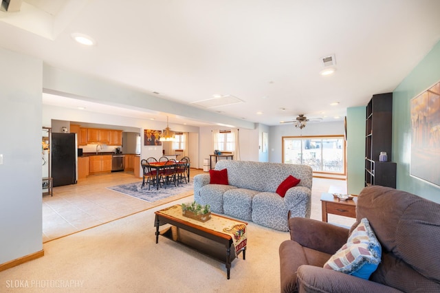 living room featuring a ceiling fan, baseboards, visible vents, recessed lighting, and light carpet