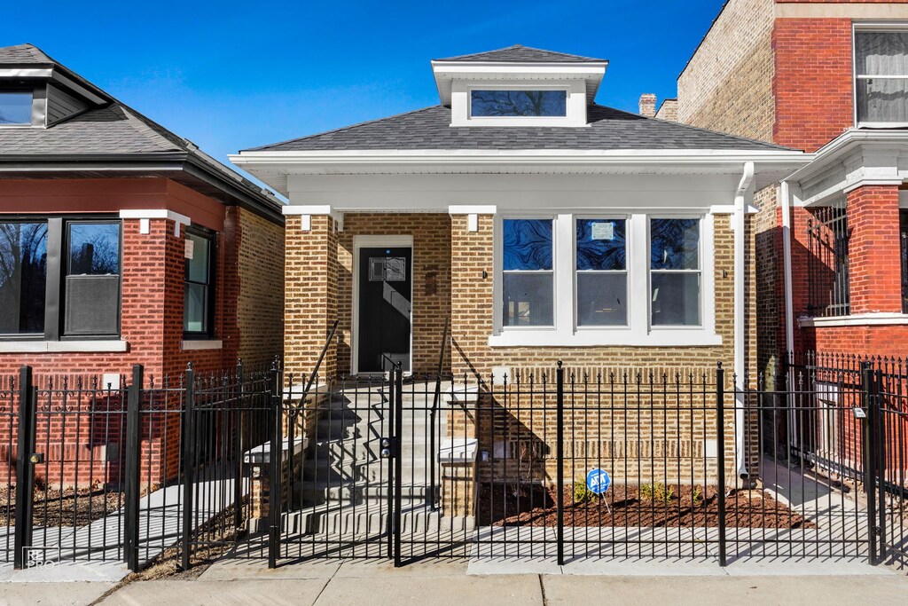 2240 W Garfield Blvd, Chicago, IL 60609 - bungalow-style home featuring brick siding, a fenced front yard, and a shingled roof