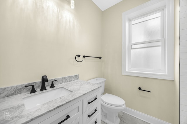 bathroom with toilet, tile patterned floors, baseboards, and vanity