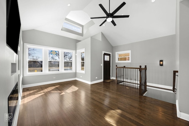 interior space with high vaulted ceiling, a ceiling fan, baseboards, and wood finished floors