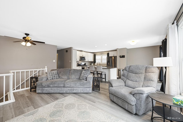 living area featuring light wood-type flooring, a ceiling fan, and recessed lighting