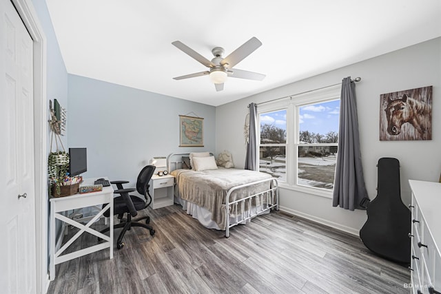 bedroom with ceiling fan, a closet, baseboards, and wood finished floors