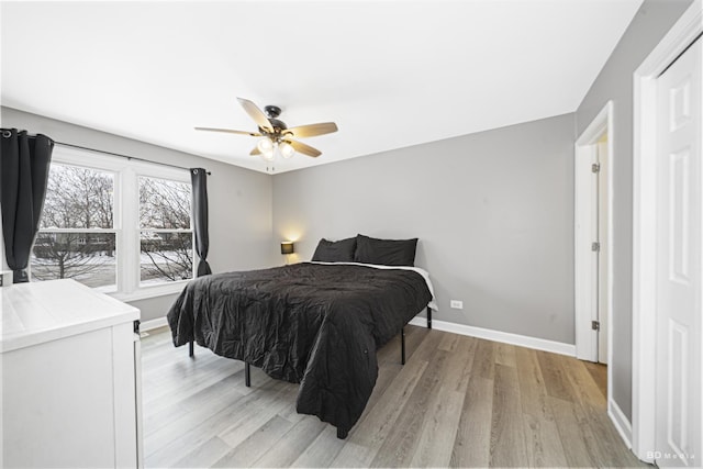 bedroom featuring light wood-type flooring, a ceiling fan, and baseboards