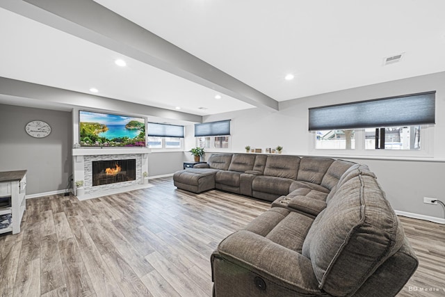 living area featuring a tile fireplace, recessed lighting, wood finished floors, visible vents, and baseboards