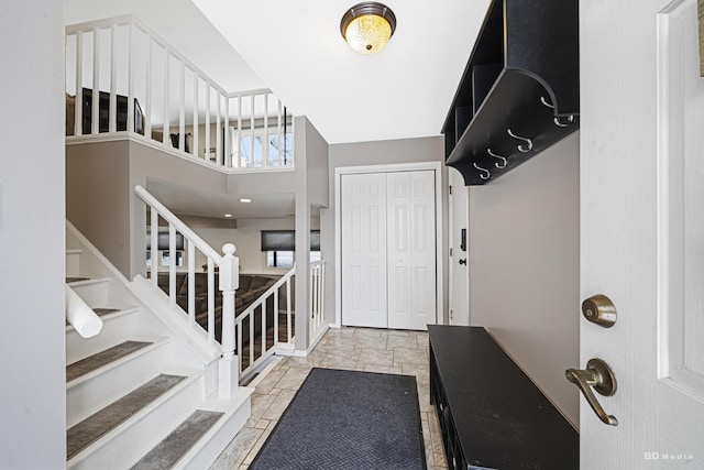 foyer entrance featuring stairs and stone tile floors