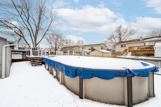 snowy yard featuring a residential view and a wooden deck