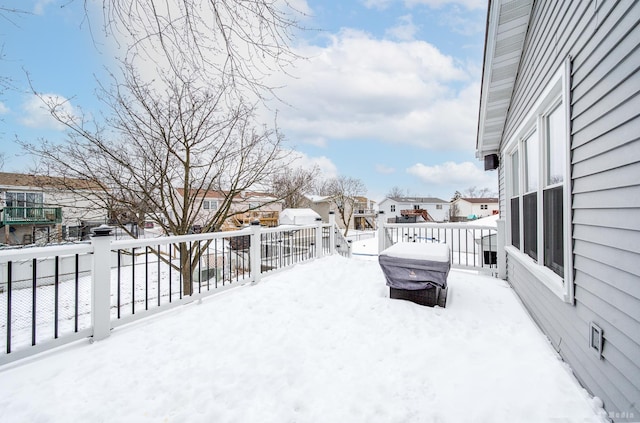 yard layered in snow featuring fence and a residential view